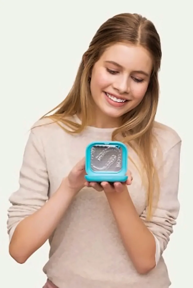 Paciente sonriendo con el estuche de sus alineadores transparentes