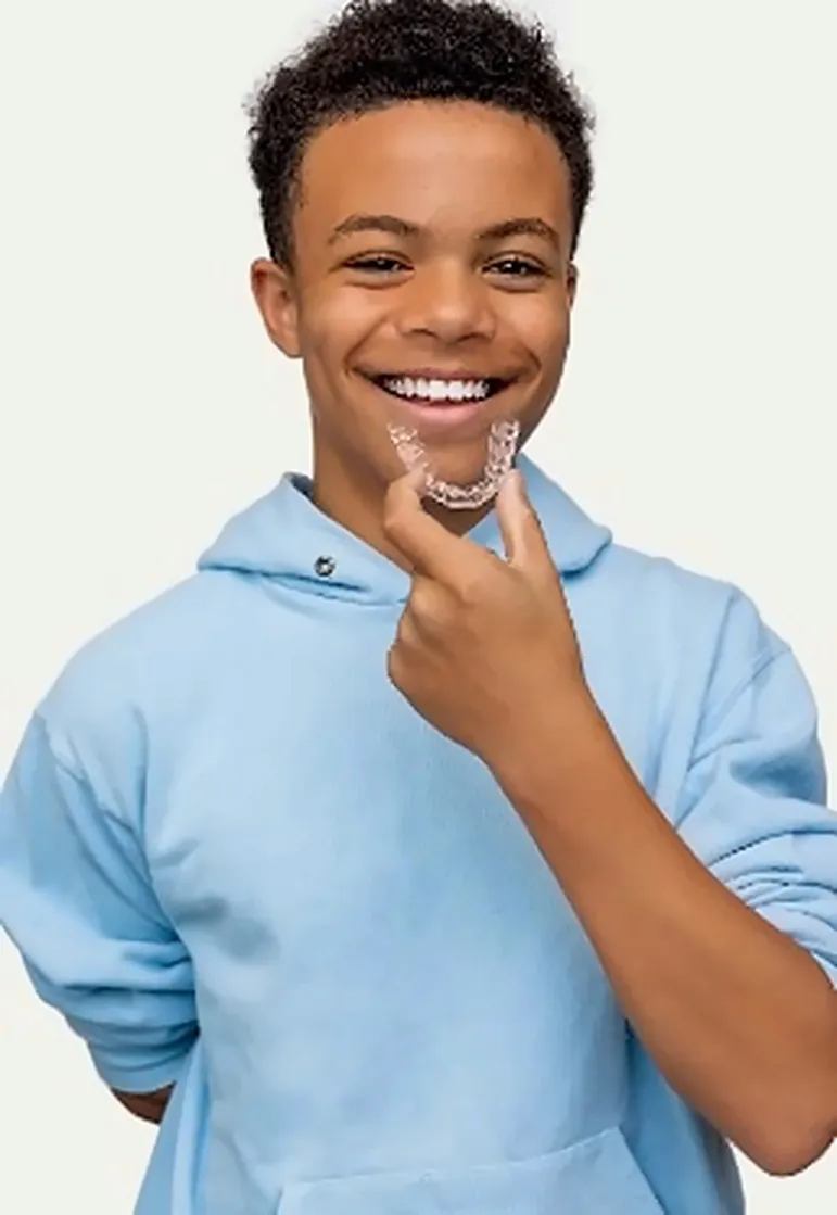 Paciente joven sonriendo con un alineador transparente